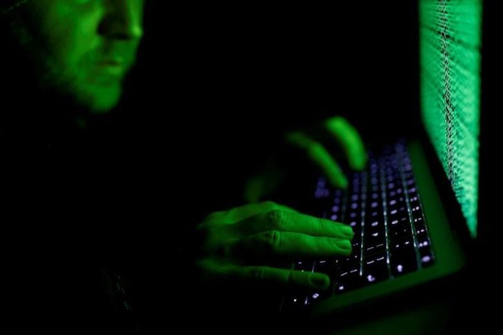 FILE PHOTO: Man types on a computer keyboard in front of the displayed cyber code in this illustration picture