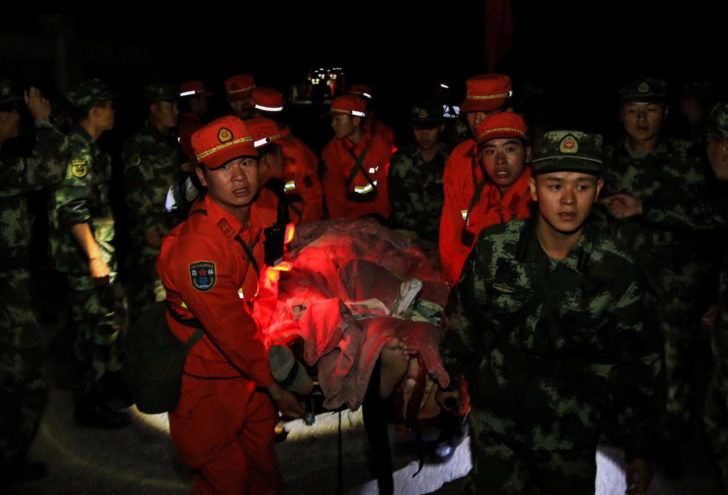 Chinese paramilitary police carry a survivor after an earthquake in Jiuzhaigou county