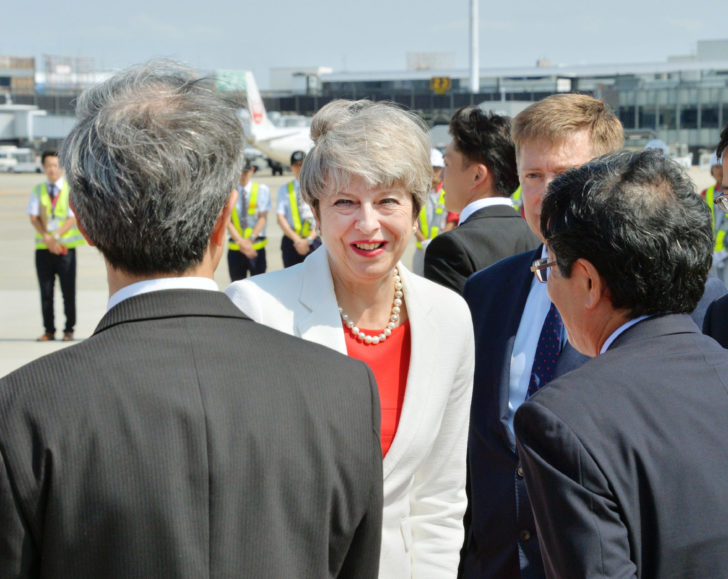 Britain's Prime Minister Theresa May is welcomed by officials upon her arrival at Itami airport in Osaka, western Japan