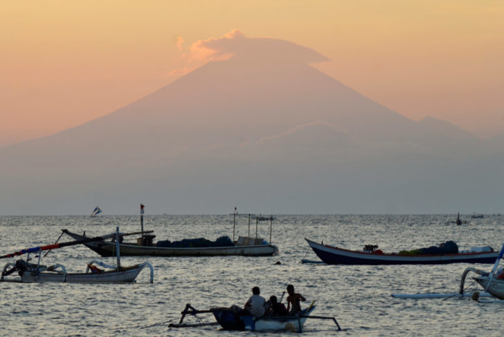 Mount Agung, an active volcano located on the resort island of Bali that has been placed on alert level 3 following recent seismic activity, is seen from Mataram on nearby Lombok island บาหลีอพยพคนกว่า 3.5 หมื่นคนแล้ว! หลังภูเขาไฟ “อากุง” ใกล้ปะทุเต็มที่