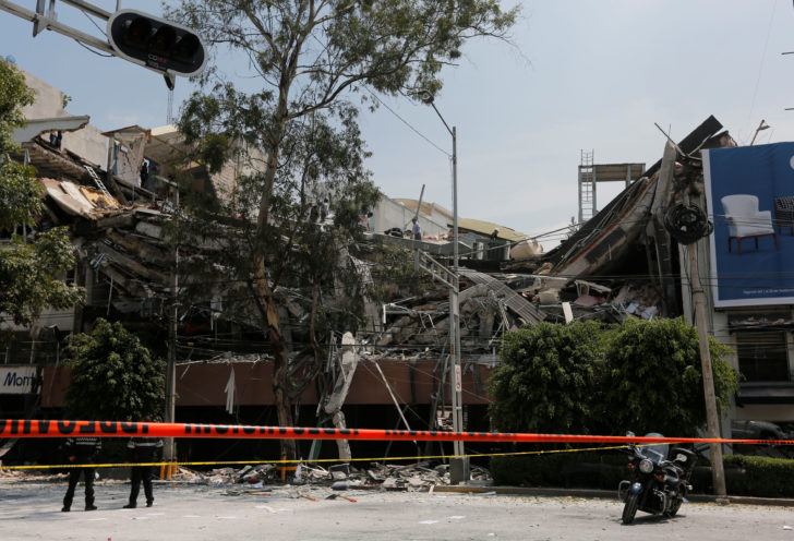 Police officers are seen next to a collapsed building after an earthquake in Mexico City
