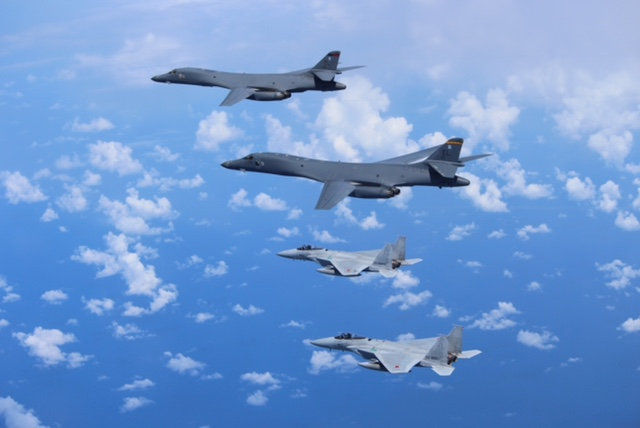 Japan's Self-Defense Forces F-15 fighter jets conduct an air exercise with U.S. Air Force B-1B Lancer bombers flying from Andersen Air Force Base, Guam, in the skies above the East China Sea
