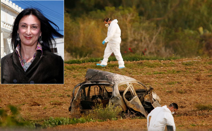 Forensic experts walk in a field after a powerful bomb blew up a car killing investigative journalist Daphne Caruana Galizia in Bidnija
