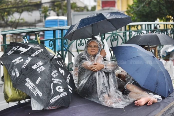 ประชาชนปักหลักรองานพระราชพิธีโดยรอบถนนราชดำเนินใน เผยแม้ฝนตกก็ไม่ย่อท้อ