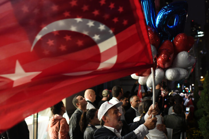 A supporter of Turkish President Tayyip Erdogan waves a U.S. and Turkish flag as he waits for him to arrive outside of The Peninsula hotel in Manhattan