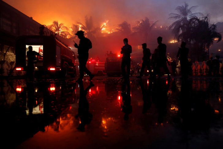 Police officers stand guard during a fire at Kandawgyi Palace hotel in Yangon, Myanmar