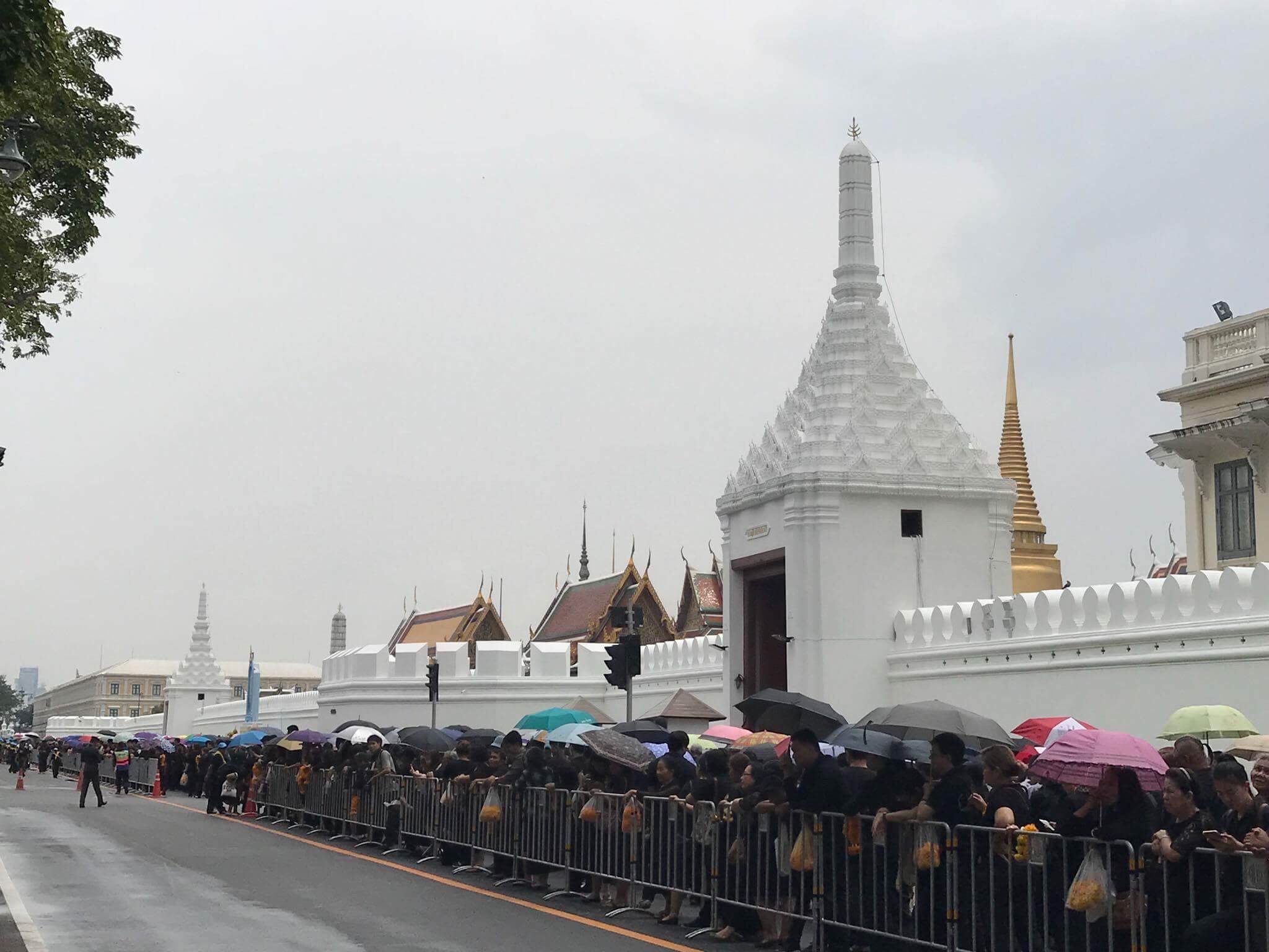พสกนิกรไม่หวั่นฝนตกเข้าแถวถวายสักการะพระบรมฉายาลักษณ์ ร.9 ข้างกำแพงวัง