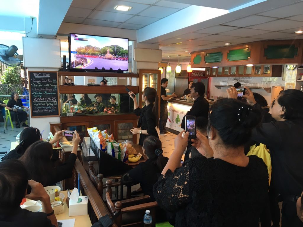 ประชาชนร่ำไห้หน้าจอทีวีขณะชมถ่ายทอดสด ใช้โทรศัพท์มือถือบันทึกภาพความทรงจำ