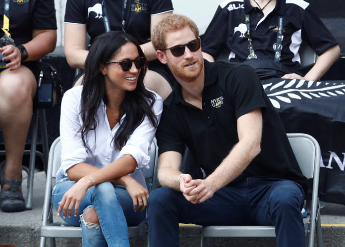 Britain's Prince Harry sits with girlfriend actress Markle to watch a wheelchair tennis event during the Invictus Games in Toronto