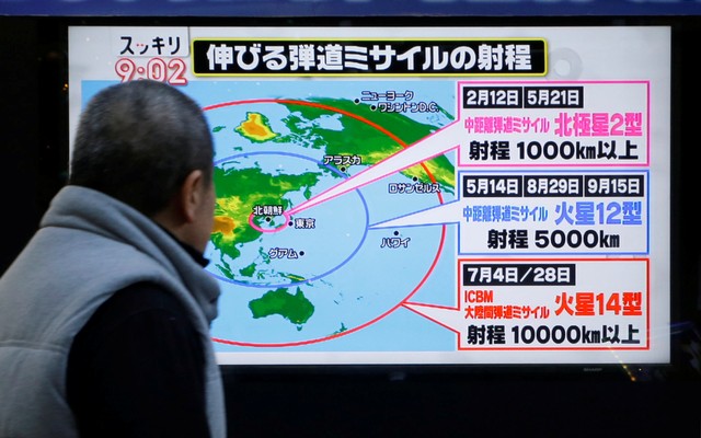 A man looks at a street monitor showing a news report about North Korea's missile launch, in Tokyo