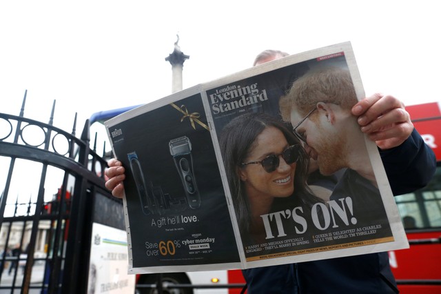 A person is seen reading the London Evening Standard with the news that Prince Harry has announced his engagement to Meghan Markle, London