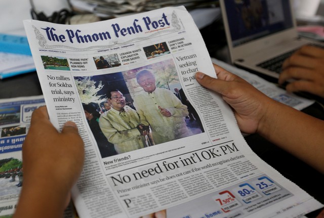 A newspaper shows a picture of Cambodia's Prime Minister Hun Sen, who shakes hands with U.S. President Trump during a gala dinner at the ongoing ASEAN Summit in Manila, in Phnom Penh สหรัฐ ประกาศห้ามชาวกัมพูชา ที่ “บ่อนทำลายประชาธิปไตย” เดินทางเข้าประเทศ