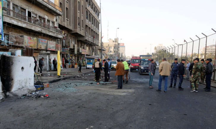Iraqi security forces inspect the site of a bomb attack in Baghdad