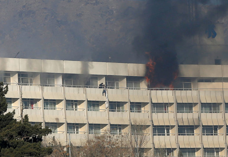 A man tries to escape from a balcony at Kabul's Intercontinental Hotel during an attack by gunmen in Kabul