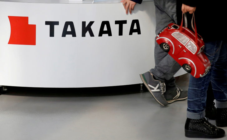 FILE PHOTO: Visitors walk past a logo of Takata Corp on its display at a showroom for vehicles in Tokyo, Japan เพื่อความปลอดภัย! ‘ออสเตรเลีย’ เรียกคืนรถ 2.3 ล้านคัน แก้ปัญหาถุงลม ‘ทาคาตะ’