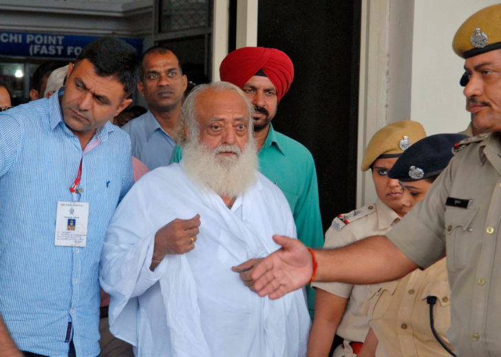 FILE PHOTO: Police escort spiritual leader Bapu outside an airport after his arrest in Jodhpur ศาลตัดสินจำคุกตลอดชีวิต “อาศรม บาปู” ผู้นำจิตวิญญาณอินเดีย ข้อหาข่มขืนสาวกสาว