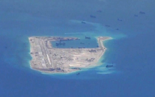 FILE PHOTO: Still image from a United States Navy video purportedly shows Chinese dredging vessels in the waters around Fiery Cross Reef in the disputed Spratly Islands