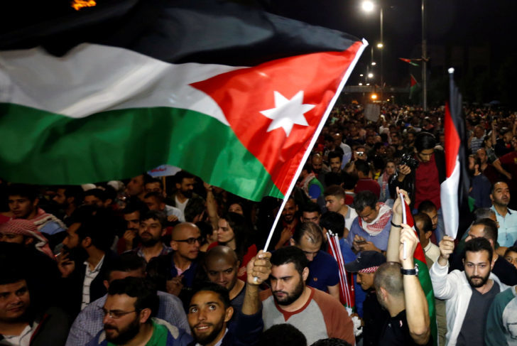 A protester holds up a Jordanian national flag during a protest in Amman, Jordan