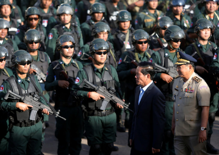 Phnom Penh Municipality Governor Khuong Sreng (2nd R), arrives as Cambodia's armed forces display anti-riot gear and assault rifles at the Olympic stadium ahead of a general election this weekend, in Phnom Penh