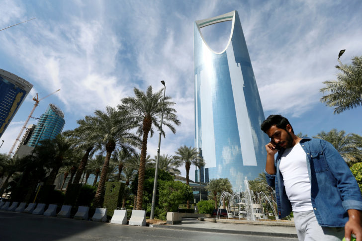 FILE PHOTO: A man speaks on the phone as he walks past the Kingdom Centre Tower in Riyadh