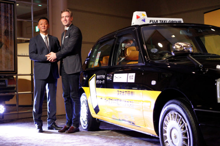 Uber Japan General Manager Tom White and Fuji Taxi Group President Hisashi Umemura shake hands during a news conference in Nagoya