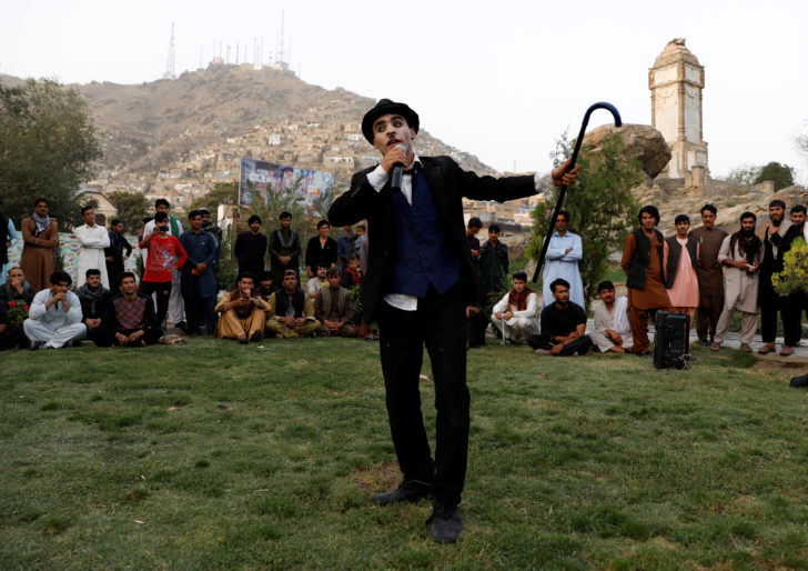 Afghanistan's Charlie Chaplin, Karim Asir, 25, performs in a school in Kabul Zoo