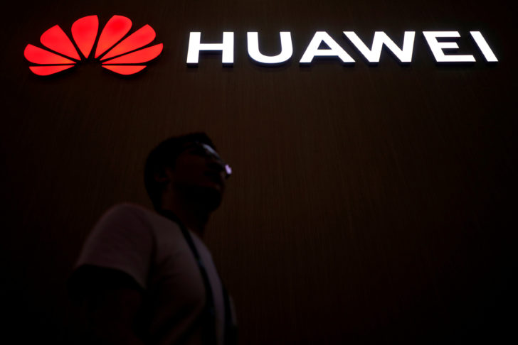 FILE PHOTO: A man walks past a sign board of Huawei at CES (Consumer Electronics Show) Asia 2018 in Shanghai ศึกหนัก! ค่ายมือถือยักษ์ใหญ่ญี่ปุ่น-อังกฤษ-ไต้หวัน หยุดสั่งซื้อสมาร์ทโฟน “หัวเว่ย” รุ่นใหม่