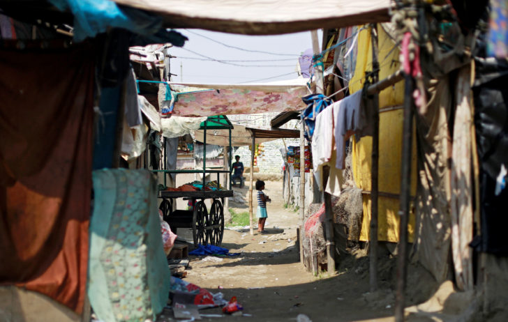 A girl from the Rohingya community stands outside a shop in a camp in New Delhi