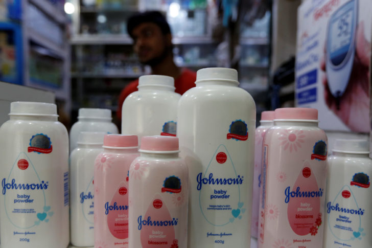 A worker waits for customers as bottles of Johnson & Johnson baby powder are displayed at a medical store in Kolkata