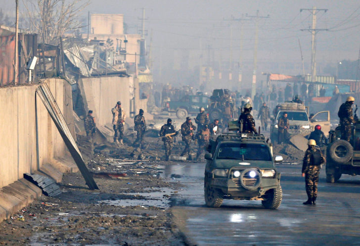Afghan security forces inspect the site of a car bomb blast in Kabul, Afghanistan