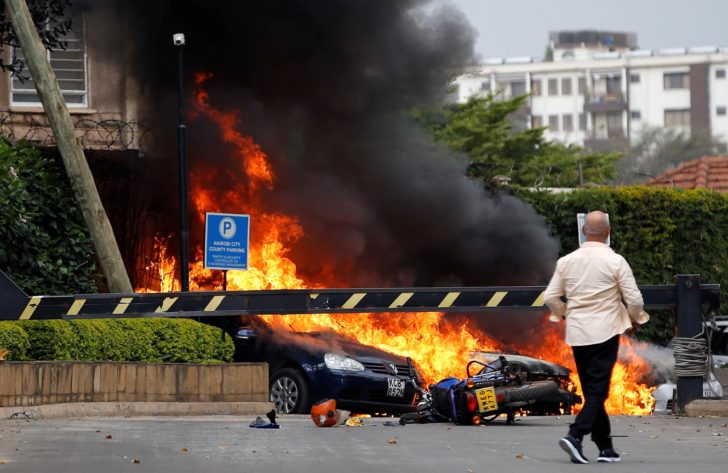 Cars are seen on fire at the scene where explosions and gunshots were heard at the Dusit hotel compound, in Nairobi