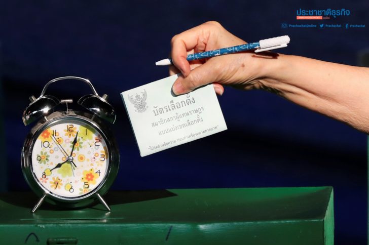 A voter casts their ballot as they vote at a polling station during the general election in Bangkok