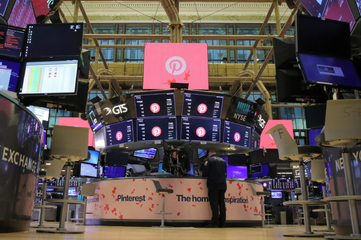 A trader works on the floor before the trading day as signage is displayed celebrating the IPO of Pinterest Inc. hangs on the front of the NYSE in New York “ยูนิคอนส์” แห่เข้าตลาดหลักทรัพย์ “พินเทอเรสต์” เปิดตัวแรงหุ้นพุ่งสูงกว่า 28%