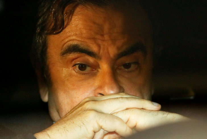 FILE PHOTO : Former Nissan Motor Chairman Carlos Ghosn sits inside a car as he leaves his lawyer's office after being released on bail from Tokyo Detention House, in Tokyo
