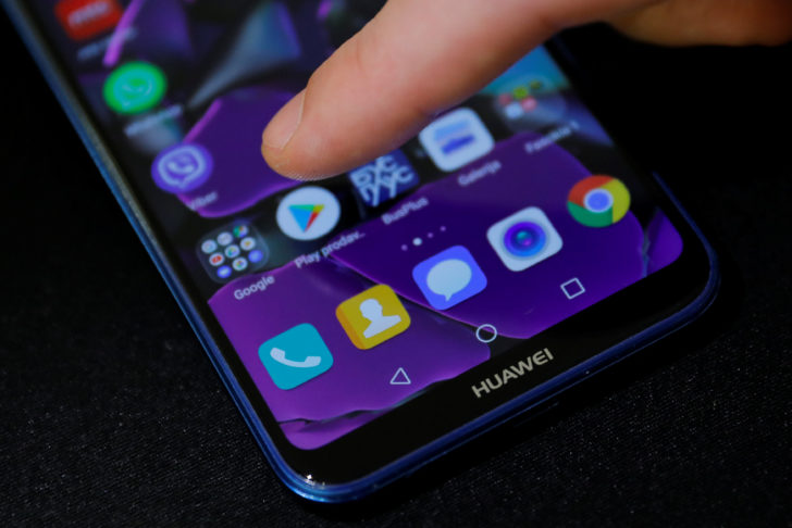 Man points a finger to the Google Play app logo on his Huawei smartphone in this illustration picture