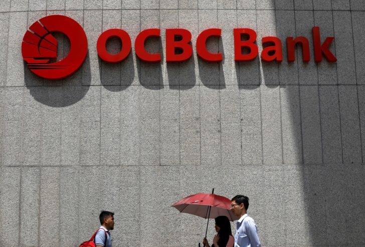 FILE PHOTO: People pass an OCBC Bank office in Singapore