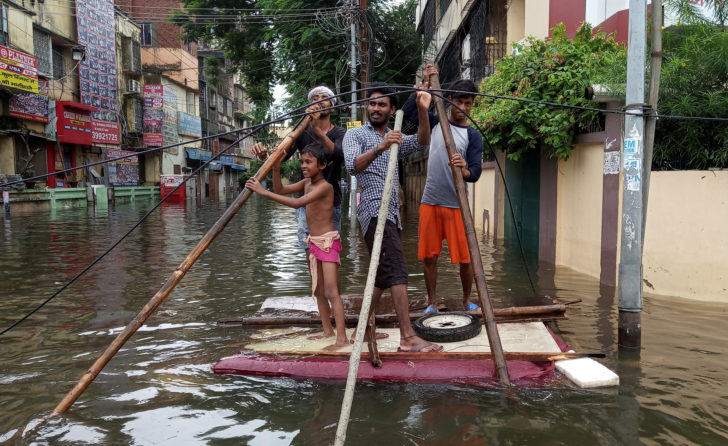 People use a makeshift raft to move out of a flooded neighbourhood in Patna เหตุน้ำท่วม 2 รัฐในอินเดียเข้าสู่วันที่ 6 พบผู้เสียชีวิตแล้วกว่า 100 ราย