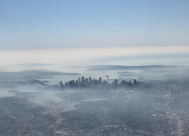 An image taken on a smart phone from a plane window shows smoke haze blanketing Sydney