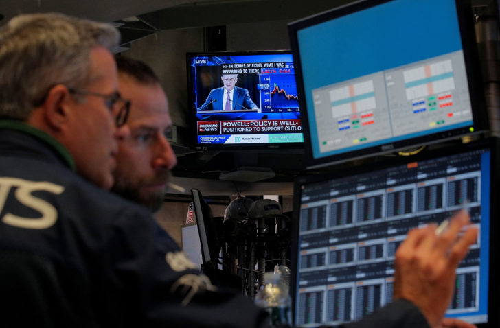 Traders work as a screen shows Federal Reserve Chairman Jerome Powell's news conference after the U.S. Federal Reserve interest rates announcement on the floor of the NYSE in New York