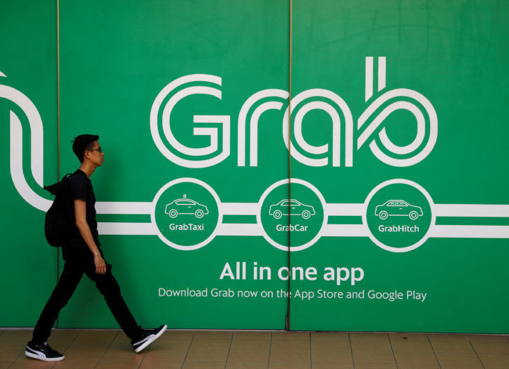 FILE PHOTO: A man walks past a Grab office in Singapore ดีเดย์ Grab ถูกกฎหมาย เข้าครม. 17 ธ.ค.-แจกเงินเวนคืนมอเตอร์เวย์ 13 ธ.ค.นี้