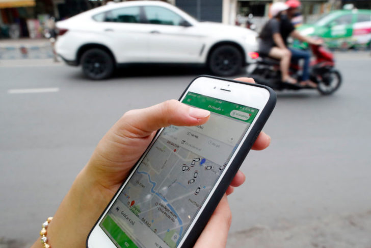 Woman using the Grab app on an Apple iPhone 6 Ho Chi Minh City.