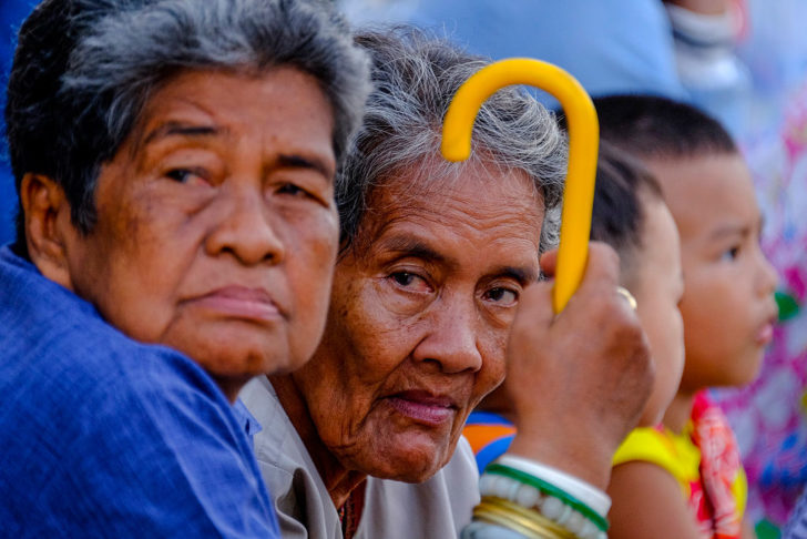 Thai grandmothers look on during a wax candle procession.