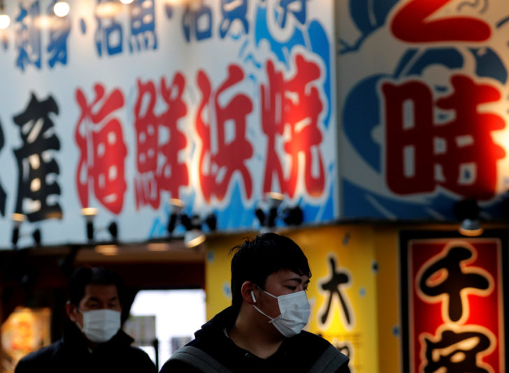 Pedestrians wearing surgical masks make their way in front of Yokohama station in Yokohama