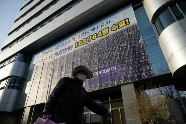 A woman wearing a mask to prevent contracting the coronavirus walks past a branch of the Shincheonji Church of Jesus the Temple of the Tabernacle of the Testimony in Daegu