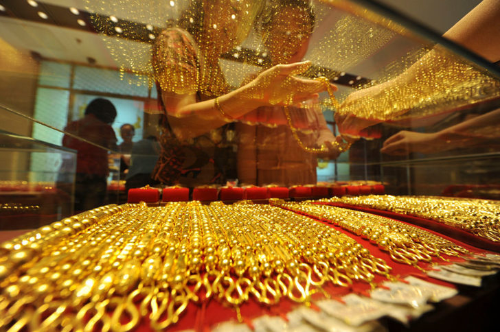 Customers buy gold nacklaces at a gold store in Hefei, Anhui province