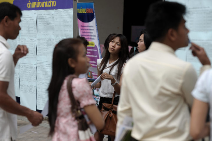 Thai workers look at job advertisements