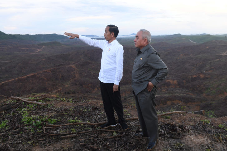 Indonesian President Joko Widodo gestures as Governor of East Kalimantan Isran Noor stands during their visit to an area, planned to be the location of Indonesia's new capital, at Sepaku district in North Penajam Paser regency