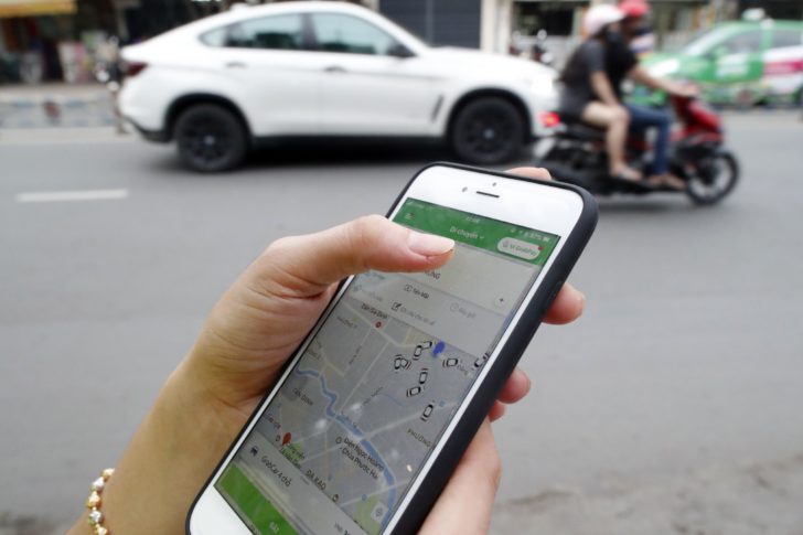 Woman using the Grab app on an Apple iPhone 6 Ho Chi Minh City Vietnam