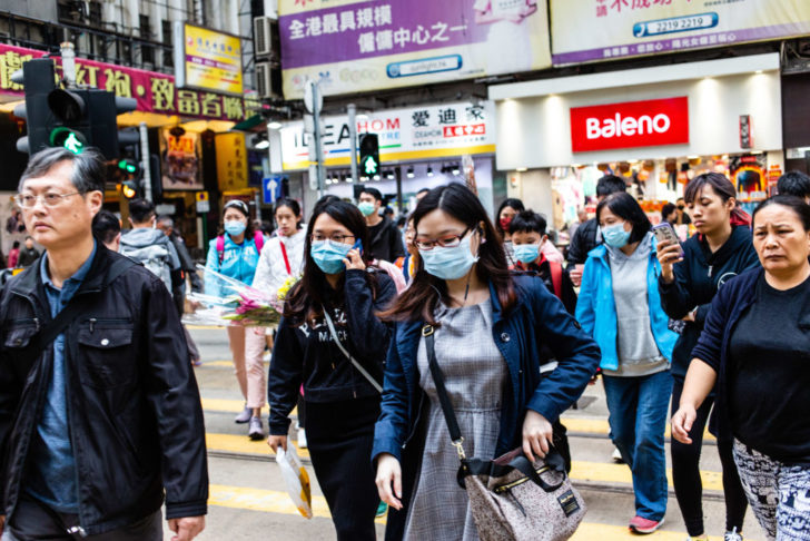 People crossing the road wear surgical masks.In light of a