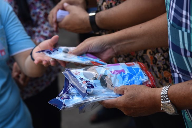 A woman receives protective masks from the staff Ministry of